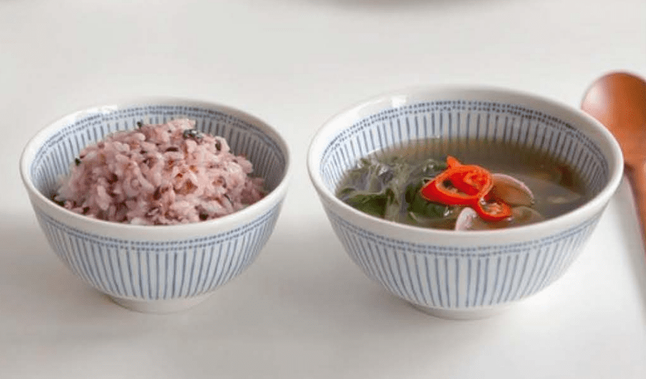 일본 가정식 느낌의 니코트 아오이 밥공기 국그릇 세트. 쪽빛 빗살무늬가 그려진 감성 도자기 식기가 나무 식탁 위에 놓여있다.